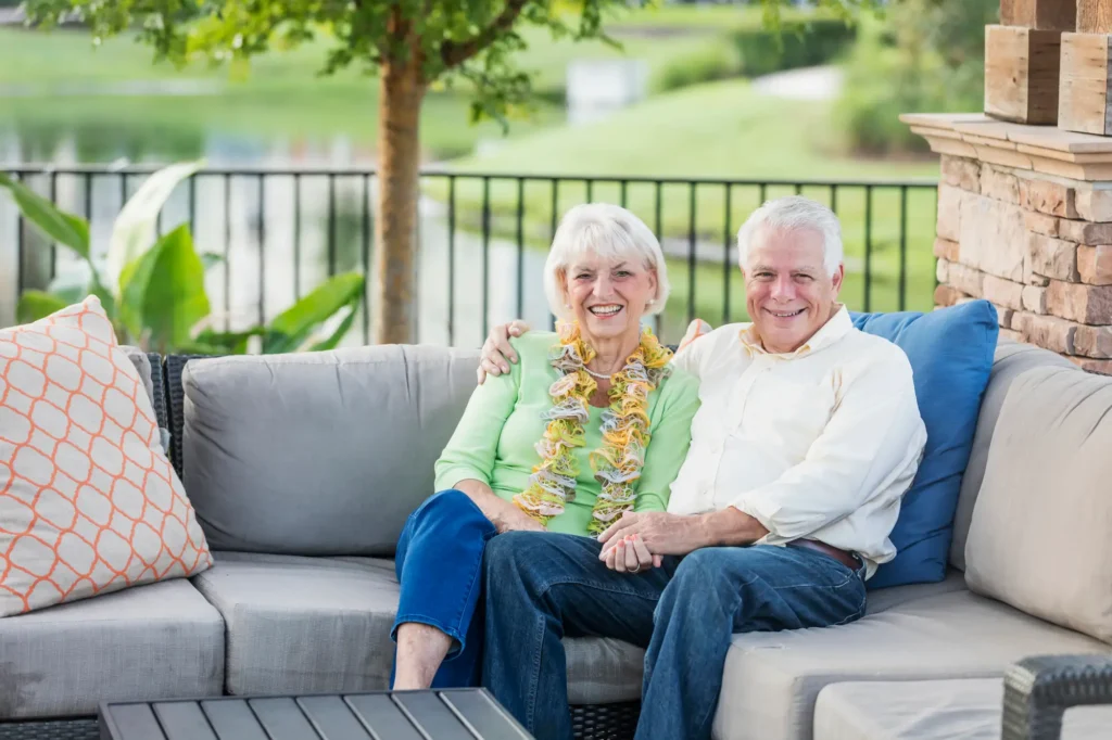 senior couple relaxes on porch sofa