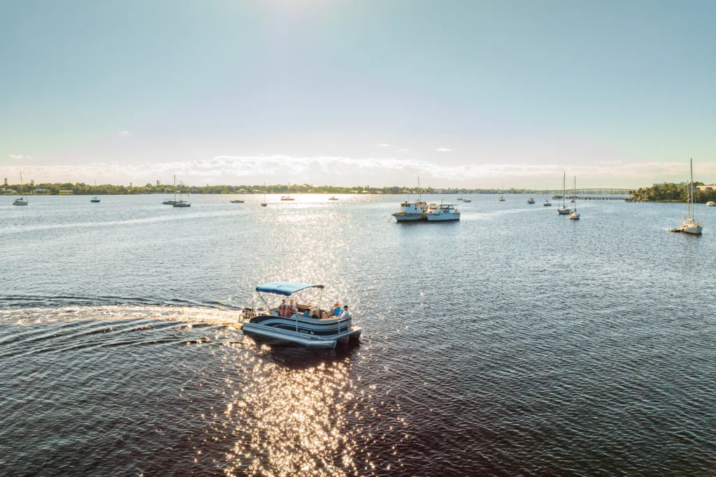 A boat on a large water canal in palm city FL. A retirement resort lifestyle is pro of retiring in Florida.