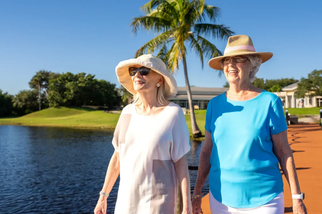 Two Sandhill Cove residents walk by the lake on campus in Palm City Beach, FL.