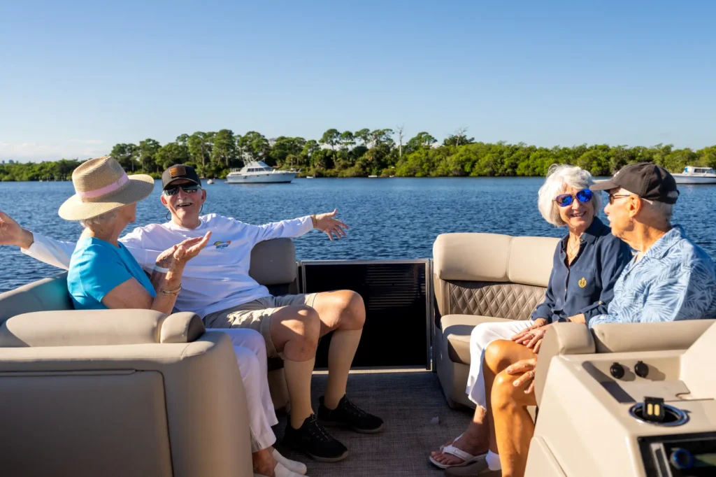 2 elderly couples on a boat in Palm City, FL talking about the best time to move to a retirement community like Sandhill Cove.