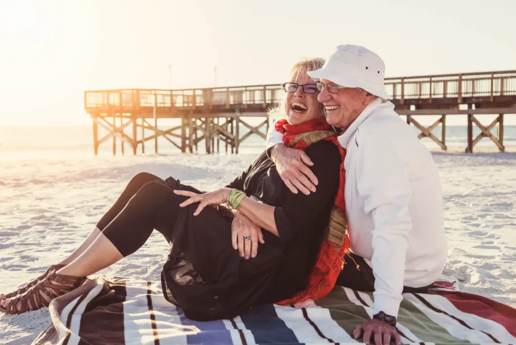 A happy senior couple on a beach considering Palm City retirement communities like Sandhill Cove 