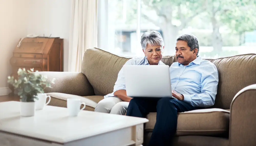 a senior couple browsing on their laptop at home
